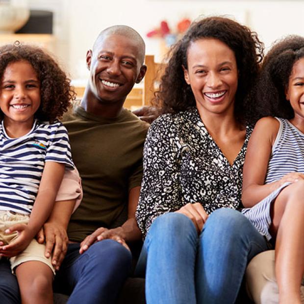 Multigenerational African American family sits together on a couch