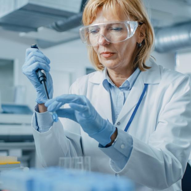 Researcher in lab taking vials