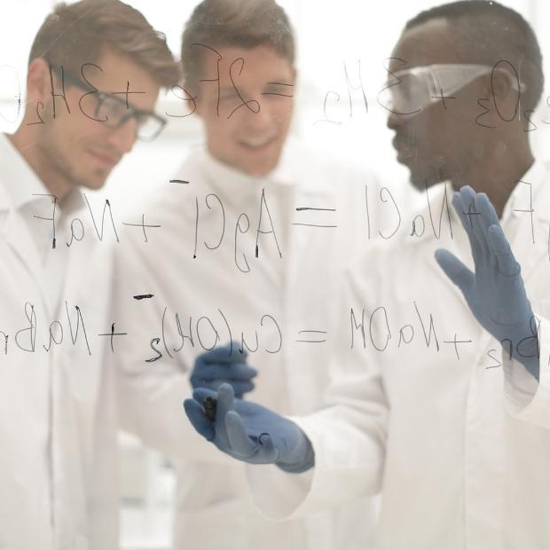 Researchers writing equations on white board