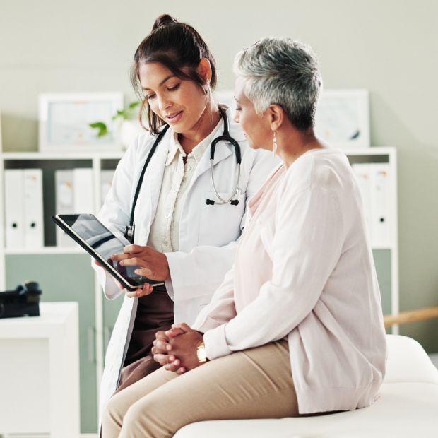 Doctor looking at tablet with patient