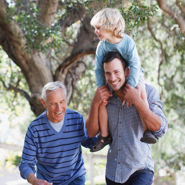 Older man walking with son, who has his son on his shoulders