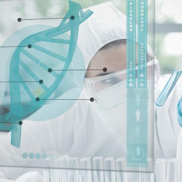 Researcher in lab looking at vial