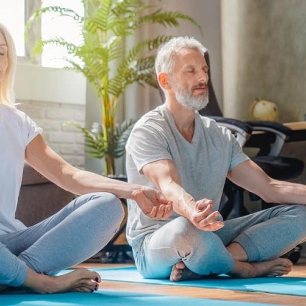 Mindfulness Monday banner - two people doing yoga in their living room