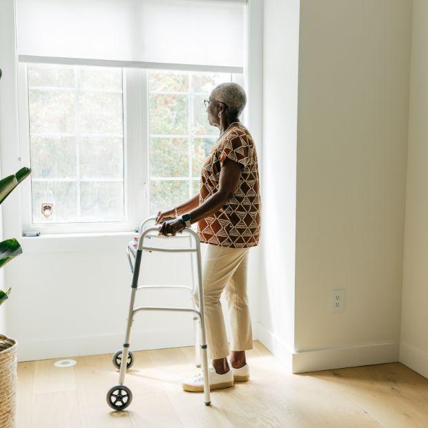 Woman using a walker while looking out her window