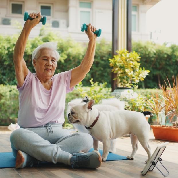 Woman working out outside with her dog.