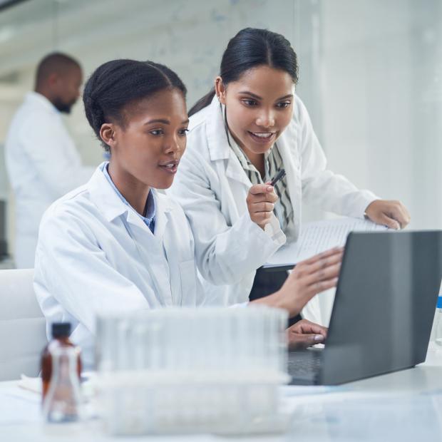Two women researchers in lab looking at a laptop