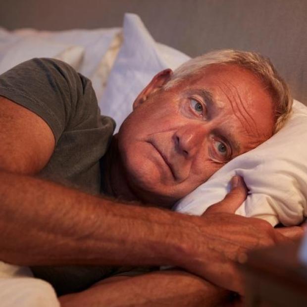 Man laying in bed with eyes open