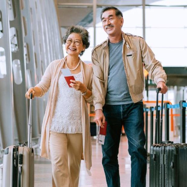 A couple walking through the airport with their bags