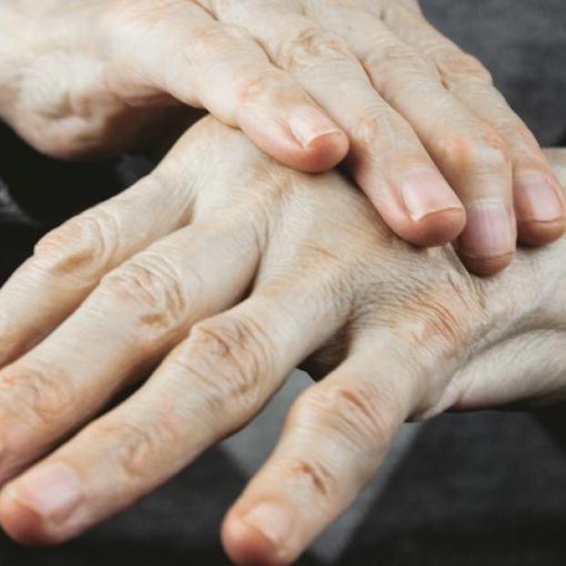 Close up of person's hands, one hand placed on top of the other