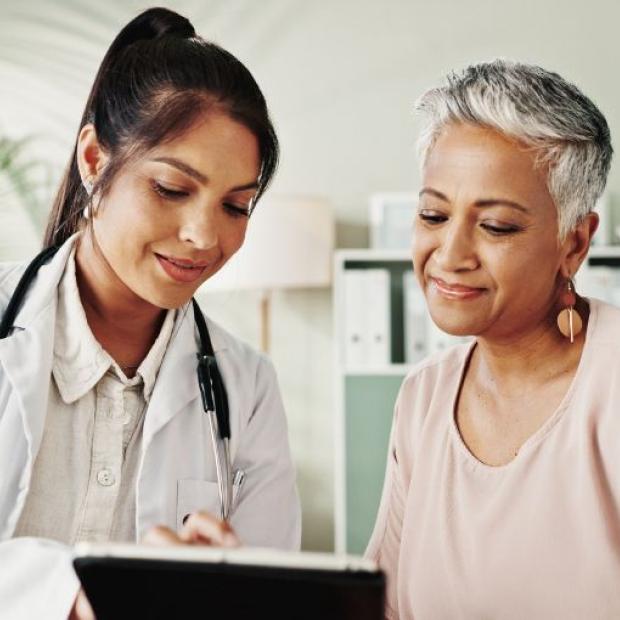 Doctor and senior woman looking at tablet together