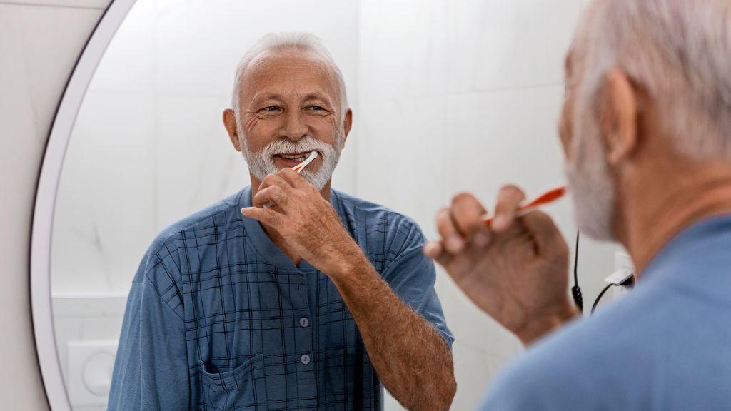Older man brushing his teeth
