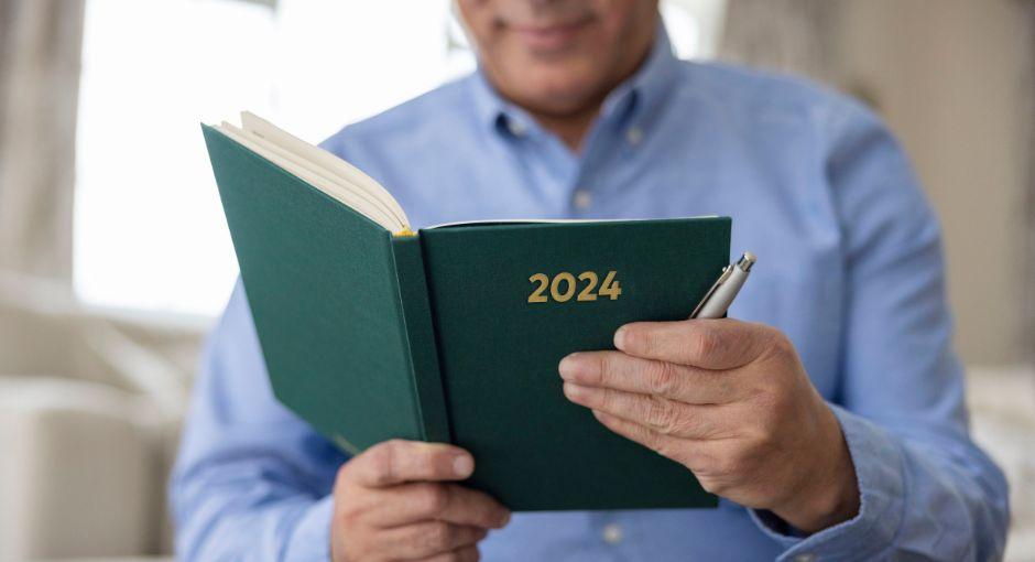 Man holding a book that says 2024