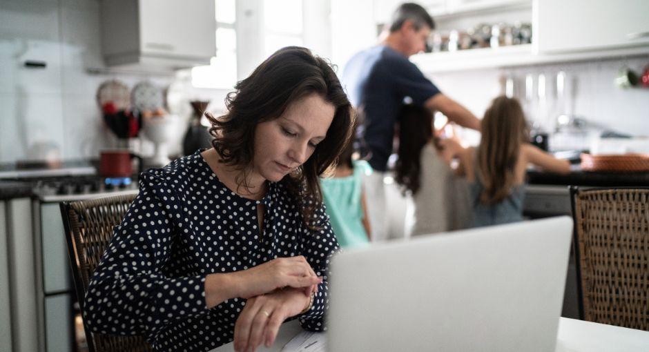 Woman working from home with family in the background
