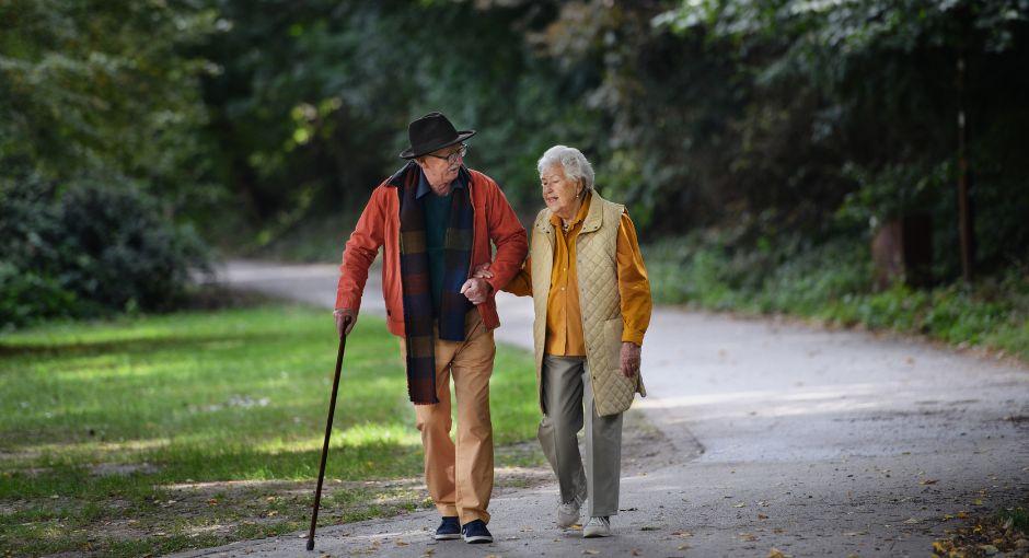 Older couple walking through a park
