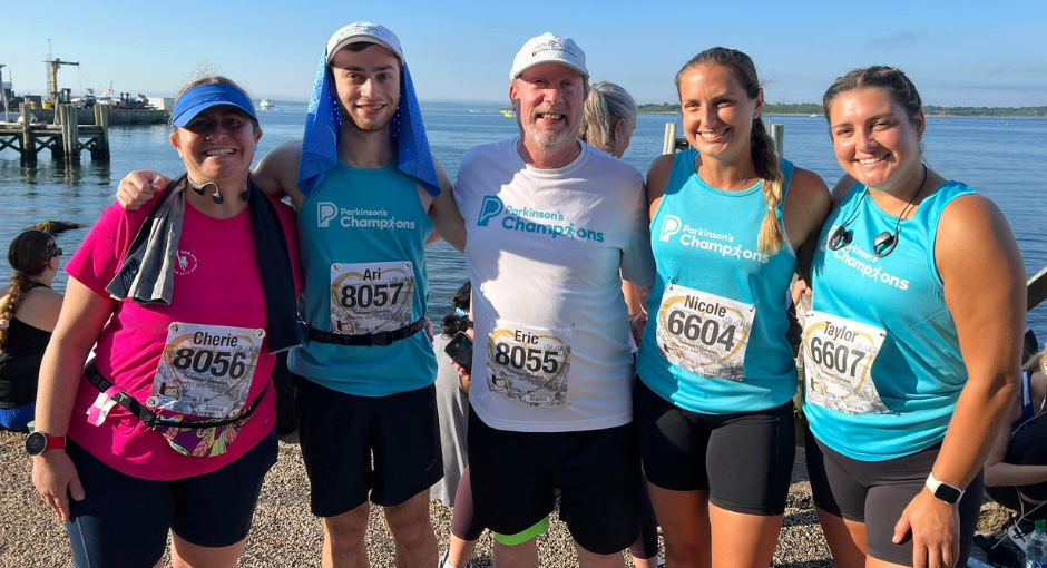 A family smiling at the camera after a Champion's event by the ocean.