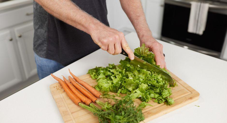 Man cutting lettuce and carrots 