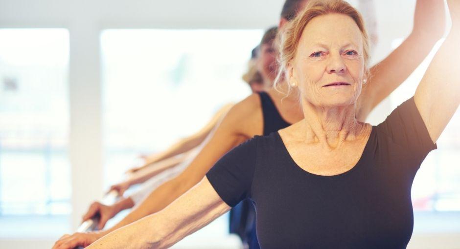 Group of women balancing on bar at ballet class