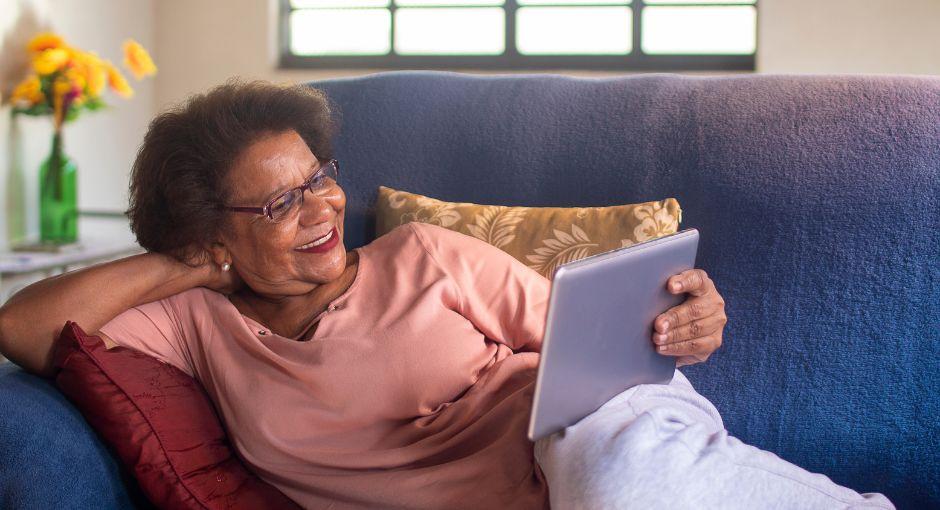 Woman on the couch looking at an ipad