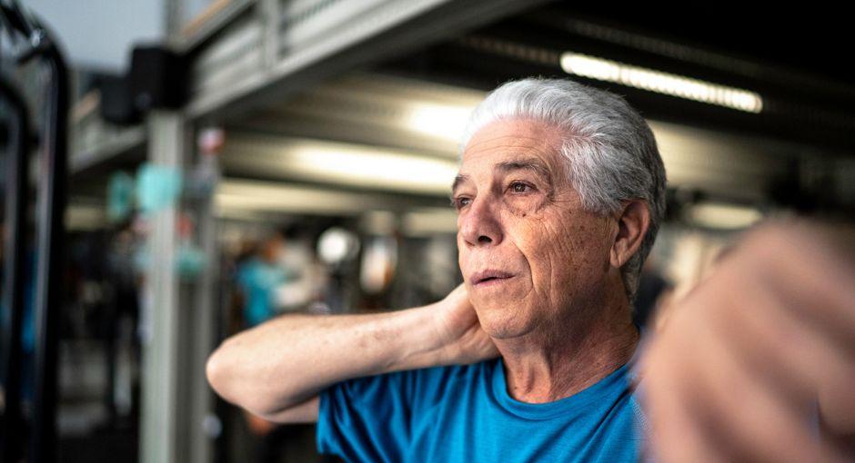 hombre sosteniendo su cuello con dolor