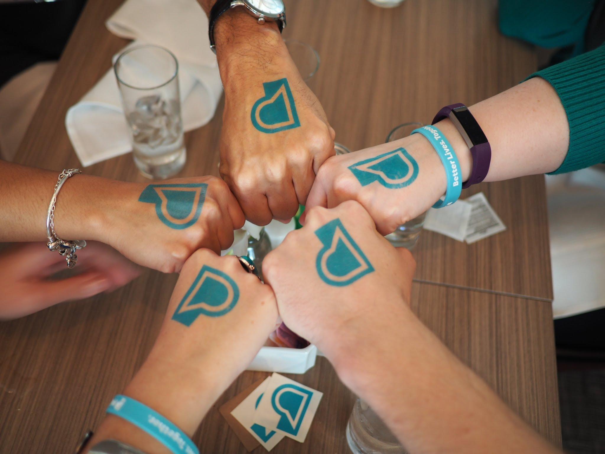 Image of hands with PF logo temporary tattoos