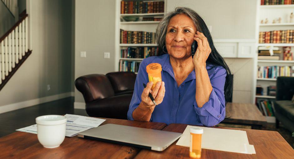 Woman talking on the phone, holding a pill bottle