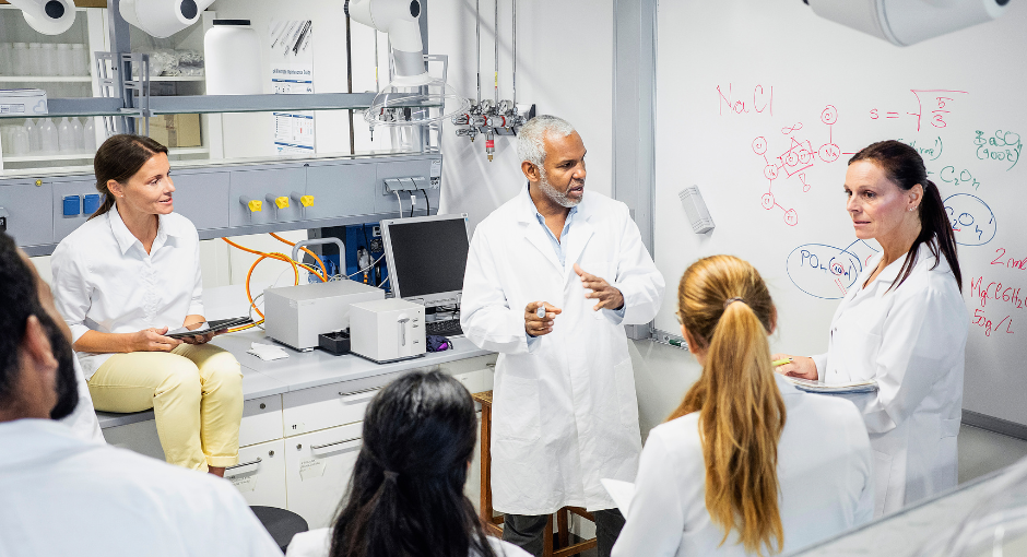 A group of researchers talking in front of white board