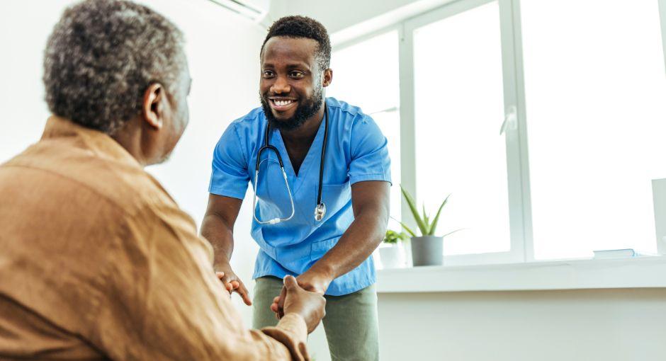 Nurse holding the hands of his patient