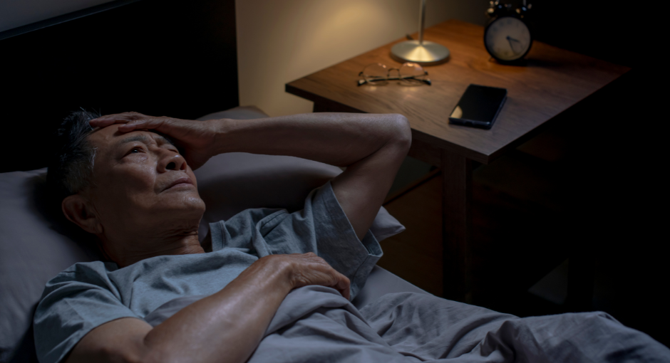 Man laying in bed having trouble sleeping