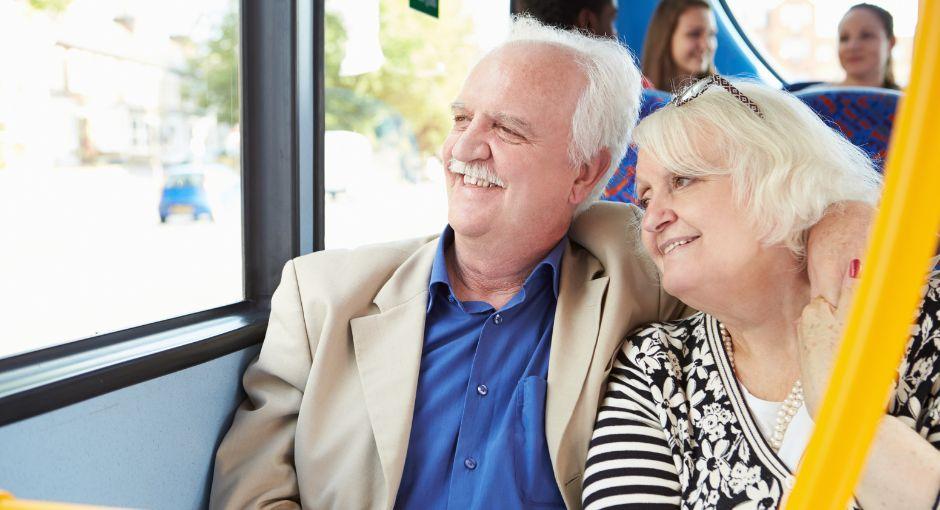Couple sitting on a bus smiling out the window
