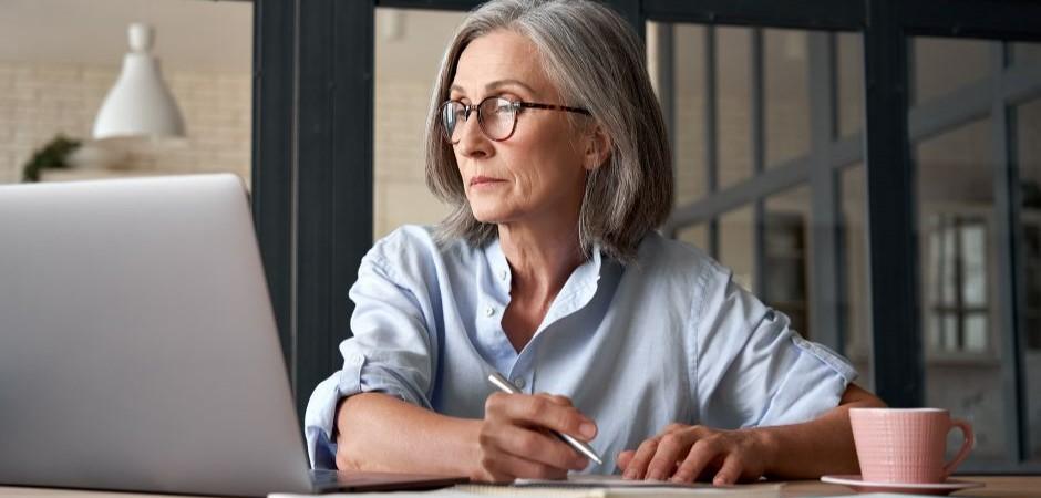 Woman writing notes from readings on laptop