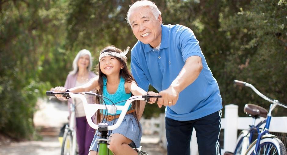Man helping child ride a bike