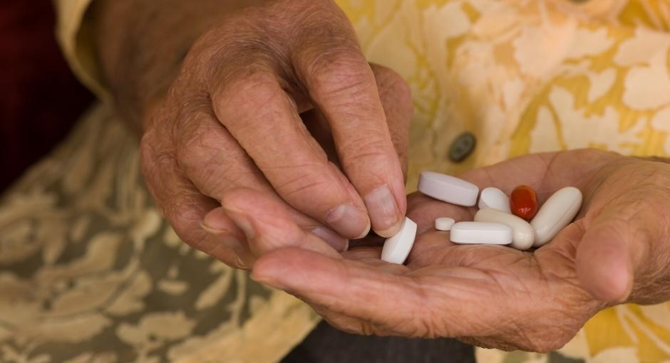 Woman holding several pills in her hand