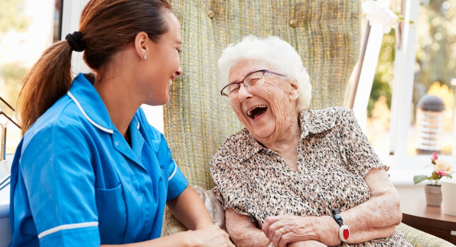 Older woman laughing with a nurse