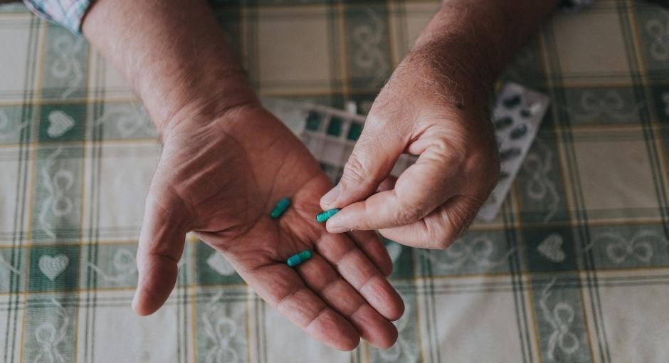 Woman holding three pills in her hands