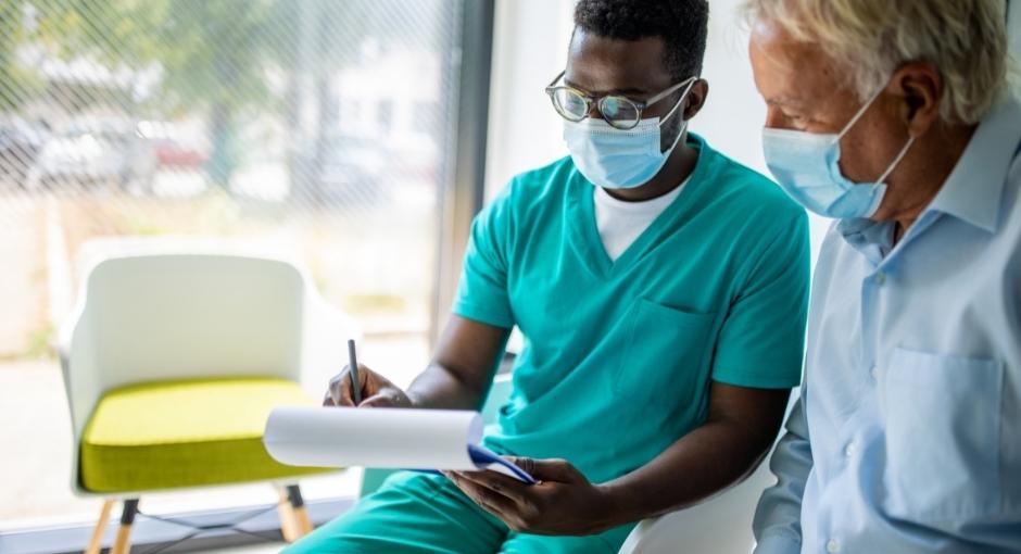 Nurse and patient looking at paper with masks on