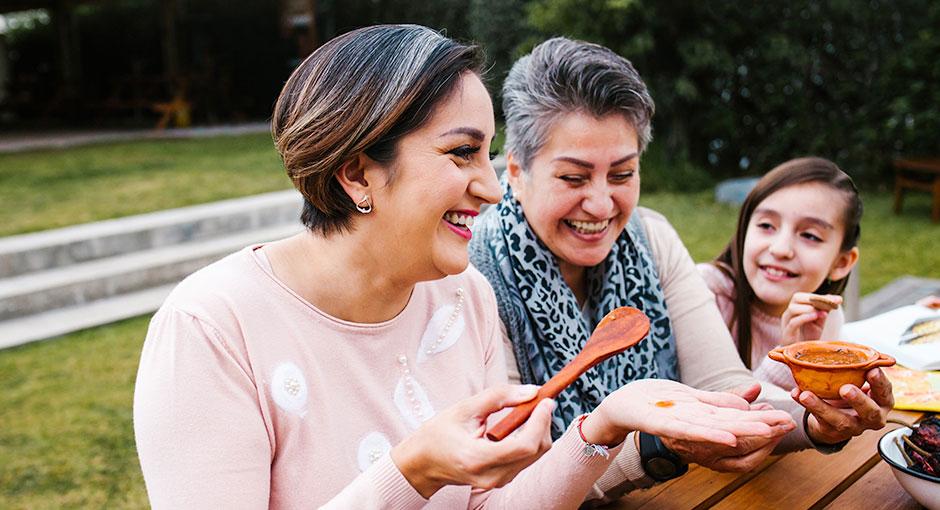 Three women from different generations bond at a picnic table