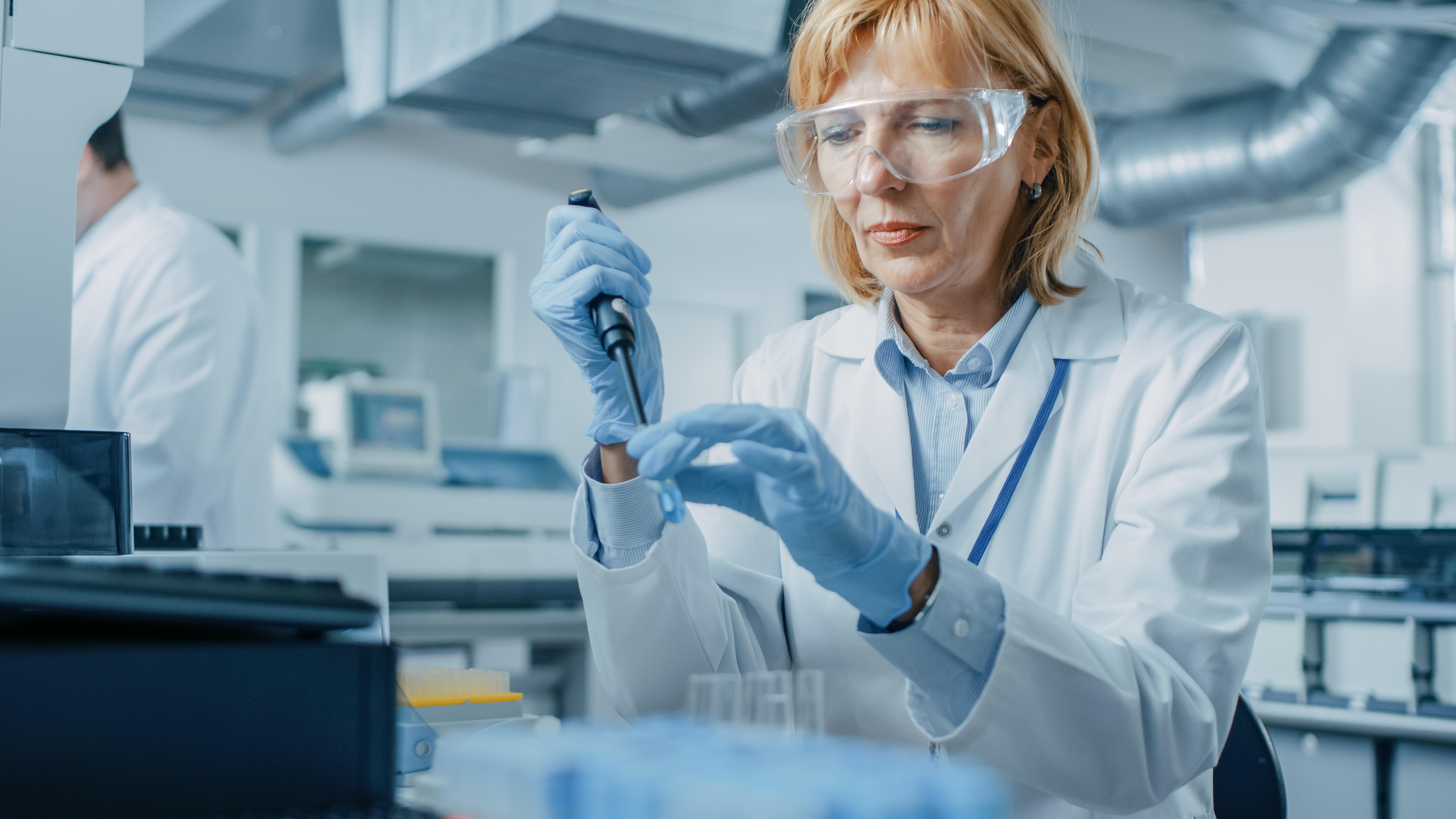 Researcher in lab taking vials