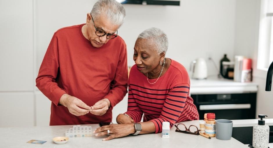 Man and woman adding pills to scheduler