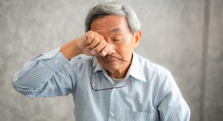 Man rubbing his eyes with the back of his hand