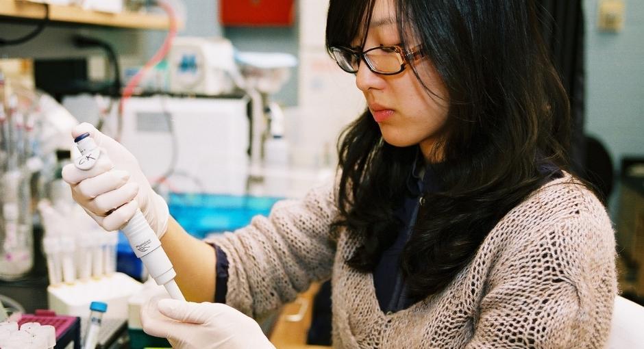 Researcher in lab taking vial