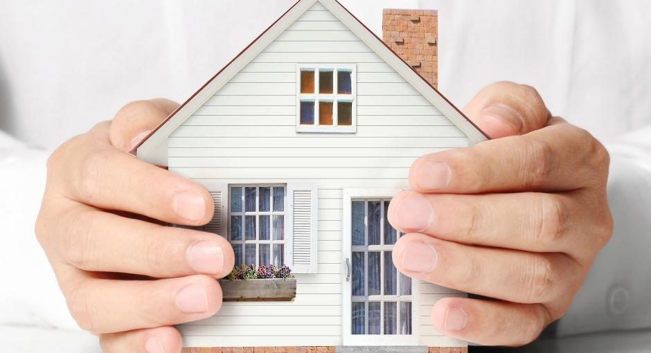 Pair of hands holding a model house