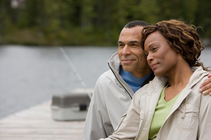 Couple sitting on a dock looking out on to the water