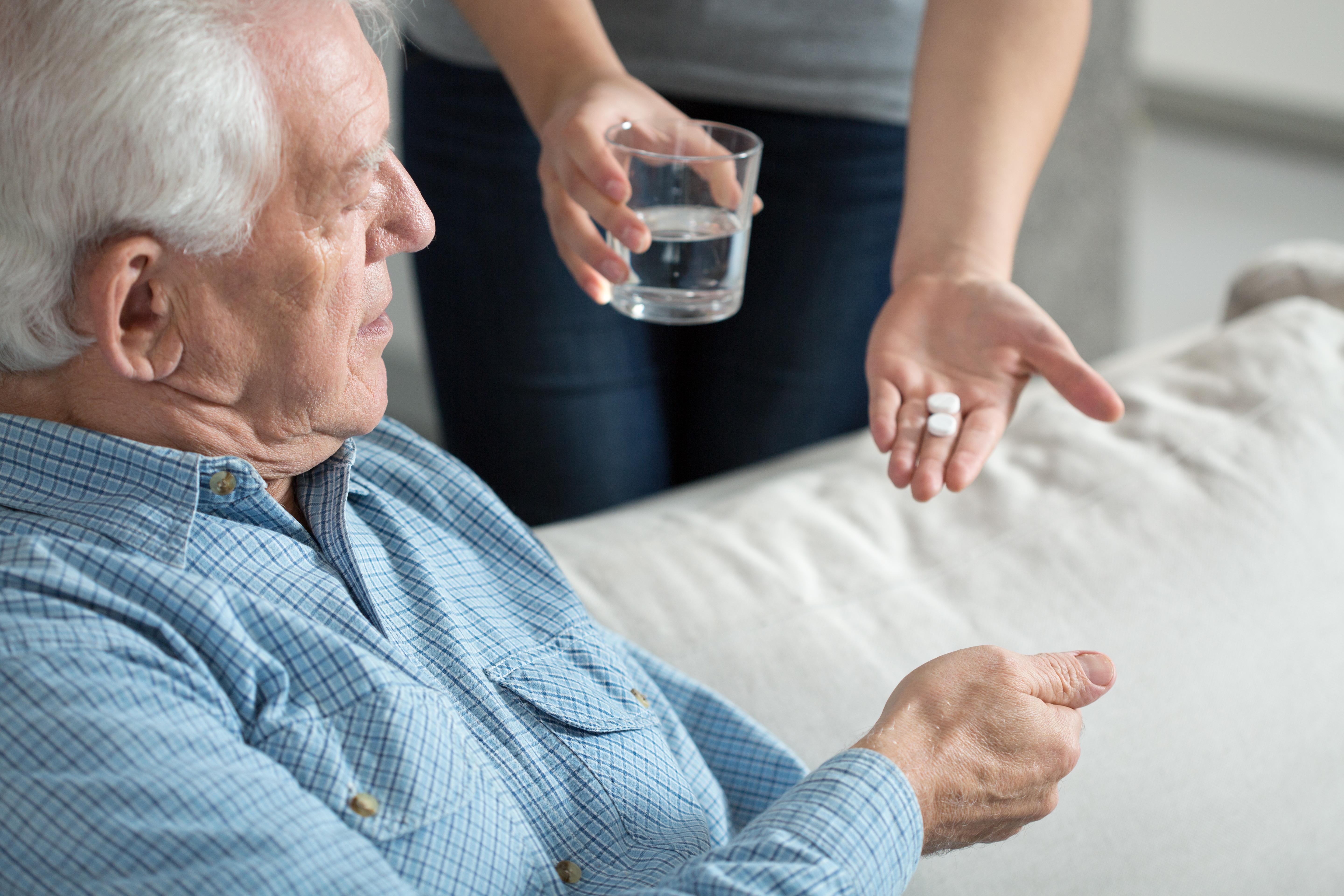 giving medications to older man
