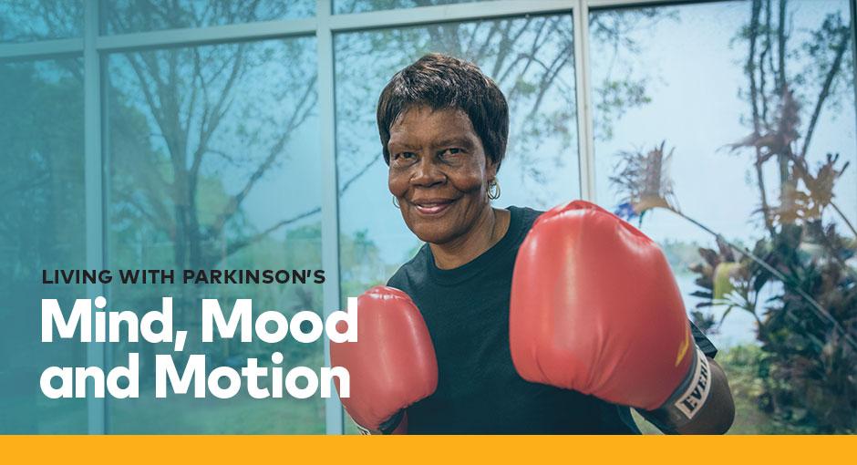 Woman with boxing gloves looks determinedly into the camera
