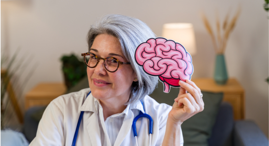 older female doctor holding a brain cutout while talking to a patient off camera