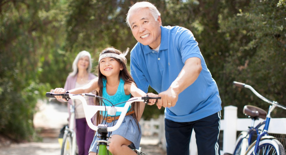 grandparent helping grandchild ride bike