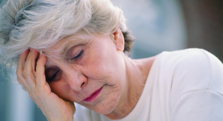 Woman with hand on head indicating headache