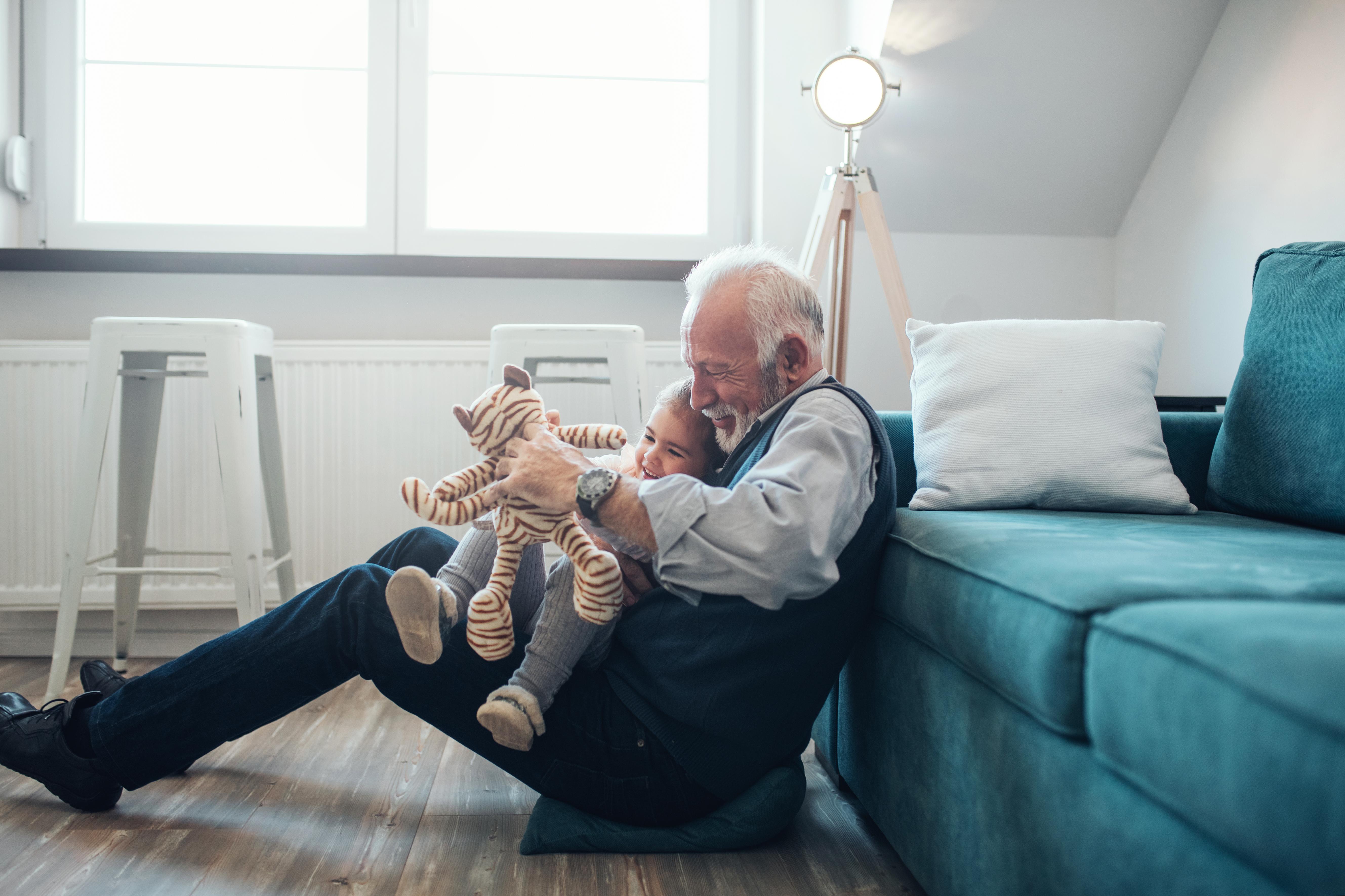 Older man playing with his granddaughter