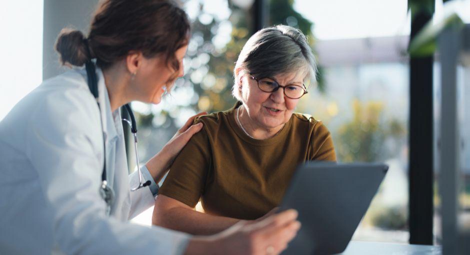Doctor showing senior woman results on a tablet.