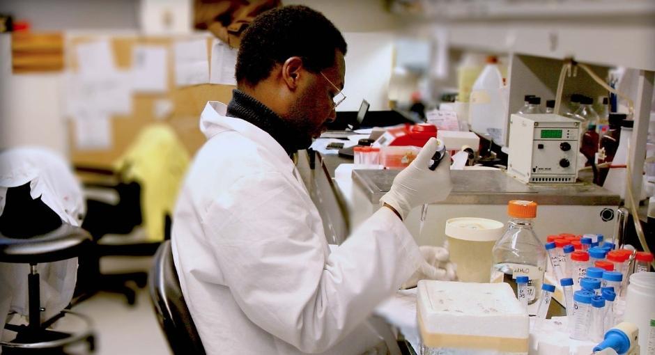 Researcher testing vials in lab